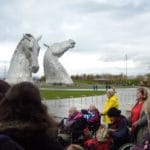 Art group taking in the views of The Kelpies on a cloudy by happy day.